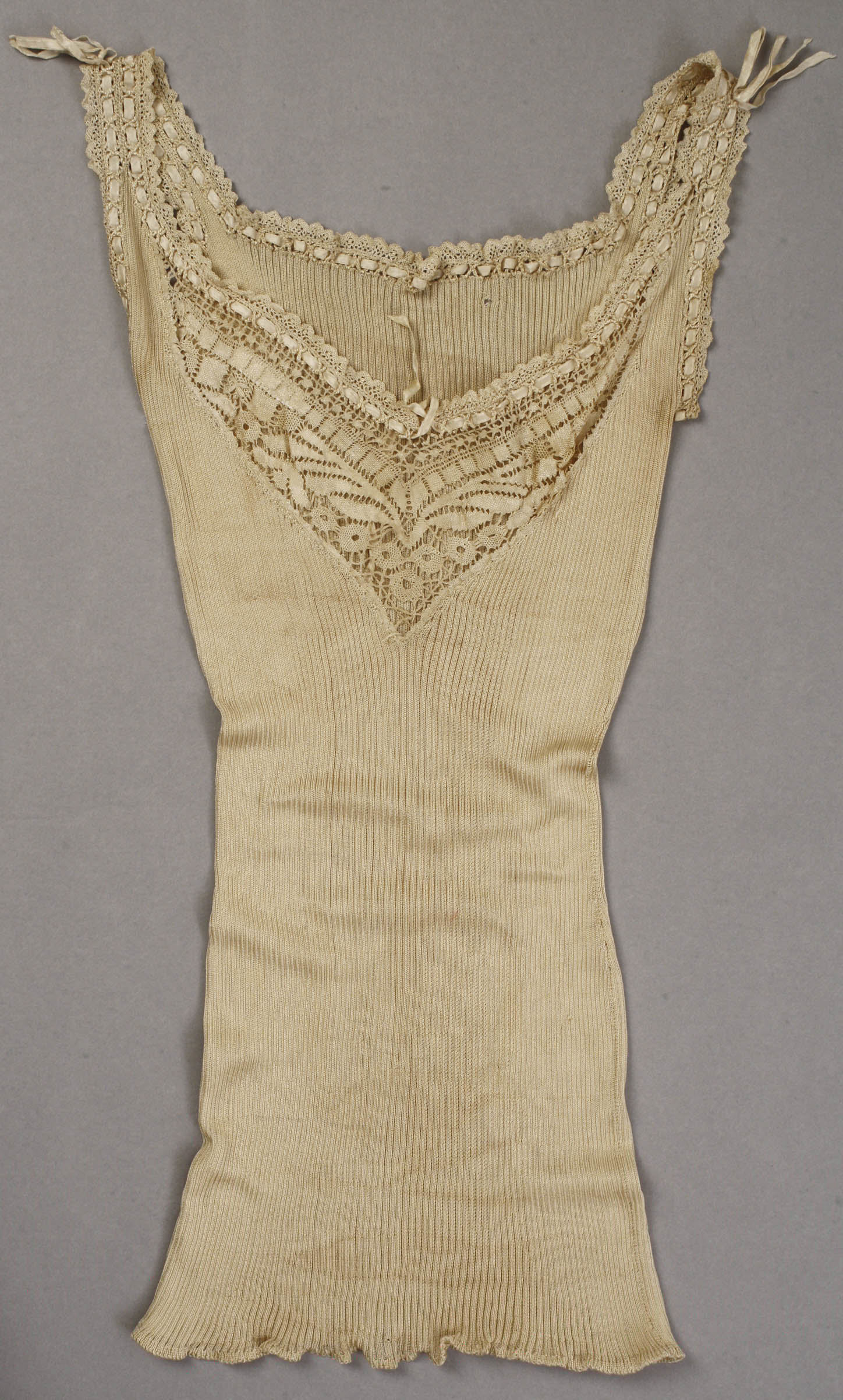 Cream cotton lingerie camisole with lace trim photographed against a neutral background